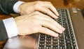 Hand typing on laptop keyboard closeup. Businessman using a laptop computer.