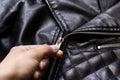 Hand unbuttones lock of black leather jacket Royalty Free Stock Photo