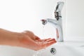 Hand under faucet with water stream