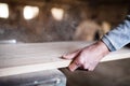 An unrecognizable man worker in the carpentry workshop, working with wood.