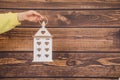 Human hand of an unrecognizable woman holds wooden lantern with hearts on a wooden background. concept of decor from natural Royalty Free Stock Photo