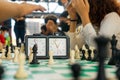 Hand of an unrecognizable young man ringing the bell of the clock in a game of chess