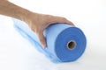 A hand unwinds a roll of blue fabric, a sheet for massage Royalty Free Stock Photo