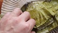 Hand unwrapping an Oaxacan Tamale made with mole wrapped in a banana leaf.