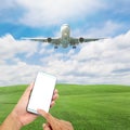 hand use smart phone with Airplane in the sky with beautiful green grass blue sky and sun light scenery background,open high seas Royalty Free Stock Photo