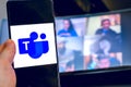 Hand use videoconference app icon of Microsoft Teams on smartphone. Royalty Free Stock Photo