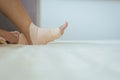 Hand using elastic bandage with leg,Female putting bandage on his injured ankle Royalty Free Stock Photo