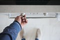 A hand is using a finger to activate the timer button on the control panel of a stainless steel oven