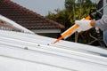 hand using glue gun or caulking gun on the roof. Royalty Free Stock Photo