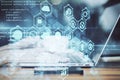 Hand using laptop with business analytics diagram and programming backdrop Royalty Free Stock Photo