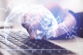 Hand using laptop and recession chart with digital earth hologram Royalty Free Stock Photo