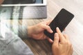 Hand using mobile payments online shopping,omni channel,icon customer network,in modern office wooden desk, blank interface scree Royalty Free Stock Photo