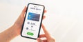 Hand using mobile phone for bitcoin to dollar exchange application. Smartphone screen display payment with credit card.