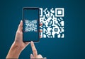 Hand using mobile smart phone scan Qr code on blue background. Royalty Free Stock Photo