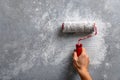 Hand using paint roller to apply textured coating on wall surface Royalty Free Stock Photo