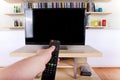 Hand using remote control in front of the TV Royalty Free Stock Photo