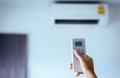 Hand using a remote control to activating air conditioning