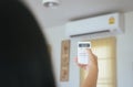 Hand using a remote control to activating air conditioning