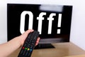 Hand using a remote control to turn off the TV with an OFF text Royalty Free Stock Photo