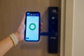 Hand using smartphone for open digital door lock at home or apartment. NFC Technology, Fingerprint scan, keycard, PIN number,