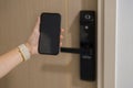 Hand using smartphone for open digital door lock at home or apartment. NFC Technology, Fingerprint scan, keycard, PIN number,