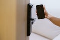 Hand using smartphone for open digital door lock at home or apartment. NFC Technology, Fingerprint scan, keycard, PIN number,