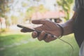 Hand of man using smartphone in park, He is typing messages with has friends through the chat application on mobile phone Royalty Free Stock Photo