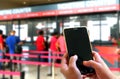 Hand using smartphone at ticketing counters Royalty Free Stock Photo