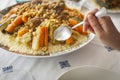 Couscous traditional moroccan with hand and spoon