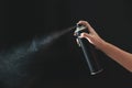 Hand using a spray, isolated on black background Royalty Free Stock Photo
