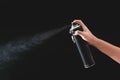 Hand using a spray, isolated on black background Royalty Free Stock Photo