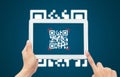 Hand using tablet computer scan Qr code on blue background. Royalty Free Stock Photo