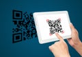 Hand using tablet computer scan Qr code on blue background. Royalty Free Stock Photo