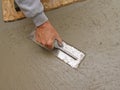 Hand using trowel to finish concrete slab Royalty Free Stock Photo