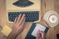 Hand is using Vintage typewriters on wooden table