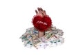 Hand with valentine heart on a background of heaps of money Royalty Free Stock Photo
