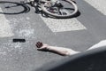 Hand of victim on pedestrian crossing next to bike after dangerous traffic accident