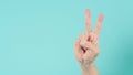 Hand is victory or v hand sign and have foam soap bubbles on a green mint or Tiffany Blue background.isolated Royalty Free Stock Photo
