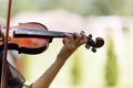 The hand of a violinist. musician performing at an outdoor wedding. Curl with violin neck close up. The actor performs at a party