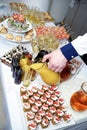 The hand of the waiter pours orange juice from a jug