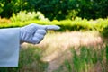 Hand of a waiter in a white glove showing a sign against a nature background Royalty Free Stock Photo