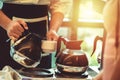 Waitress pour coffee in cup at the hotel in the morning