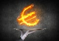 Hand of waitress presenting flaming euro sign. Royalty Free Stock Photo