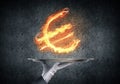 Hand of waitress presenting flaming euro sign. Royalty Free Stock Photo