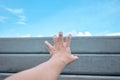 Hand with blue sky and concrete wall in background. Royalty Free Stock Photo