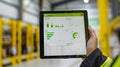 the hand of a warehouse worker operates a tablet, managing a digital construction system with a dashboard, against the Royalty Free Stock Photo