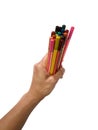 The hand was holding and delivering a lot of crayons on a white background. Royalty Free Stock Photo