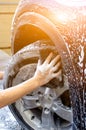 Hand washing car tire with black sponge Royalty Free Stock Photo