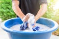 Hand washing clothes in Blue basin