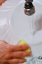 Hand washing dishes. Hand with sponge and sink in kitchen washing dirty dishes - plate Royalty Free Stock Photo